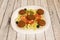 falafel plate with salad of lettuce, tomato, white onion, sweet corn, iceberg lettuce and black olives with cucumber served in a