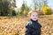 Fall. Adorable child boy with leaves in autumn