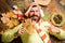 Fall and autumn season concept. Man bearded cheerful face lay on wooden background with orange leaves top view. Hipster