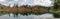 Fall color forest and foliage panorama landscape surround an idyllic mountain lake in the Alps of Switzerland on a late autumn day