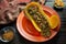 Fall colors with Butternut Squash Boat filled with ground beef with sliced olives on a red plate with some red pepper flakes on t