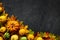 Fall dark stone background with autumn leaves and little pumpkins, top view and copy space