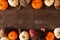 Fall double border of mixed pumpkins and acorn decor, above view on a dark wood background