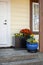 Fall flowers decorate the front door stoop of a house.