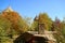 Fall foliage in the church courtyard with the ancient khachkar or Armenian cross-stone