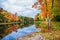 Fall foliage colors reflected in still lake water in New England