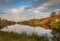 Fall foliage surrounds Lake Marcia as High Point Veteran`s Monument stands atop the mountain at sunset