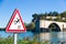 Fall hazard sign and Avignon bridge in a sunny day