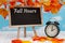 Fall Hours sign with an alarm clock with standing blackboard with fall leaves