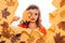 Fall look. Makeup girl peek through torn paper. Pretty girl cover face with autumn leaf. Young woman look out of hole