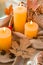 Fall maple leaf with text AUTUMN on Autumn season design concept. Candles on windowsill rainy weather. Warm Cozy hygge