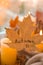 Fall maple leaf with text AUTUMN on Autumn season design concept. Candles on windowsill rainy weather. Warm Cozy hygge