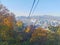 Fall maple leaves foliage Autumn with city apartments scene and cable car tower in Seoul, South Korea