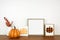 Fall mock up wood frame with wooden pumpkin and signs, and autumn leaves on a wood shelf