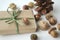 Fall mood. Acorns, tree nuts and seeds with a pine cone and a gift-wrapped box in brown paper and raffia with copy space.