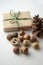 Fall mood. Acorns, tree nuts and seeds with a pine cone and a gift-wrapped box in brown paper and raffia with copy space.