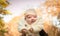 Fall. Newborn baby on a background of autumn yellow foliage. Mom`s hands. Backlight shooting