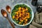 Fall salad with kale, roasted pumpkin, seeds and dried cranberries in bowl. Grey background.  Mock up. Top view