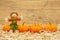 Fall scene with scarecrow and orange pumpkins on straw hay with weathered wood background