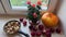 Fall season harvest. Pumpkin and red apples for delicious pie on window sill with potted roses in autumn. October mood