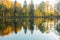 Fall season start idyllic lake reflections of fall foliage. Colorful autumn foliage casts its reflection on the calm waters