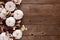 Fall side border of white pumpkins, berries and dusty red leaves against a rustic wood background