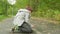 Fallen boy teenager from skateboard on asphalt path in summer park. Skateboarder lying on asphalt road in city park
