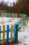 Fallen multi-colored fence of a playground at the edge of the forest