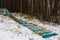 Fallen multi-colored fence of a playground at the edge of the forest