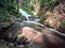 Fallen rocks and rapids in forest.  Curved mountain stream