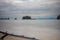 Fallen tree on the beach of Pantai Tanjung Rhu on the malaysia island Langkawi. Clouds over the bay. Silky water. Silk effect in