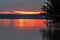 Fallen tree pointing to early morning red sunrise on Rend Lake, Illinois