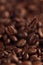 Falling coffee bean on background of heap of roasted beans.