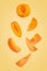 Falling down apricot slices isolated on trendy coloured background
