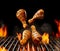 Falling down barbecue bbq grilled chicken drumsticks with golden crust and spices. Flaming fire, ember charcoal, smoke