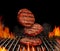 Falling down beef cutlets for burgers. Meat roasted on metal barbecue BBQ grill with flaming fire and ember charcoal on