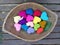 Falling flower and leaf on colourful hearts in wooden tray in the garden