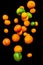 Falling fruits, citruses, oranges, pummelo, limes, tangerines and grapefruits on black background