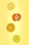 Falling halves of orange, lemon, lime and mandarin isolated on yellow background with copy space.