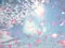 Falling heart  sunshine blue sky fluffy white clouds falling pink petals   copy space summer  nature sunlight floral background