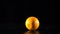 Falling orange fruit on black background, slow motion