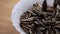 Falling roasted dietary nutritious sunflower seeds into a white ceramic bowl