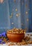 Falling sugar cornflakes in a ceramic bowl close-up top view. light breakfast scattered on the table with blue flowers close-up