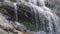 Falling water drops over the rocks in the waterfall Thusharagiri Kerala