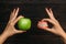 False teeth denture against green granny smith apple. Dental prosthesis care. Denture and Apple in the hands of a doctor. Dental c