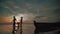 Famil walking on a lake at sunset. Silhouettes of a little children and parents time together next, run and play.