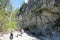 Families hiking the Grotto Canyon trail with rock climbers climbing the walls in the background, outside Canmore, Alberta, Canada.