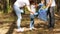 Family activists collect garbage in the woods. The child puts the garbage in a biodegradable bag. The concept of caring