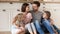 Family with adorable kids hugging sitting on warm floor indoors