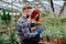 Family agriculture business in a flower greenhouse two gardener lady and man analyzing the plants from the pot they